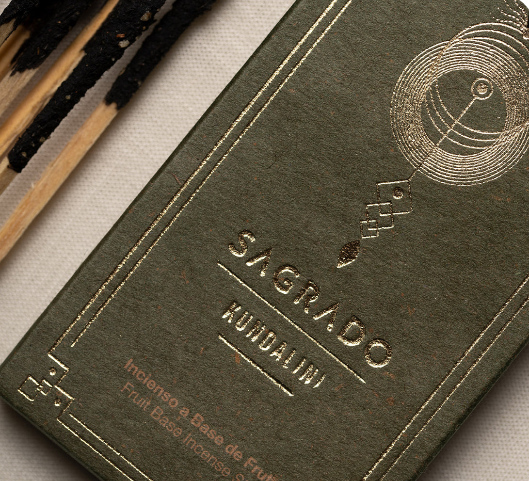 Embossed Sagrado Kundalini box photographed flat on a dark surface