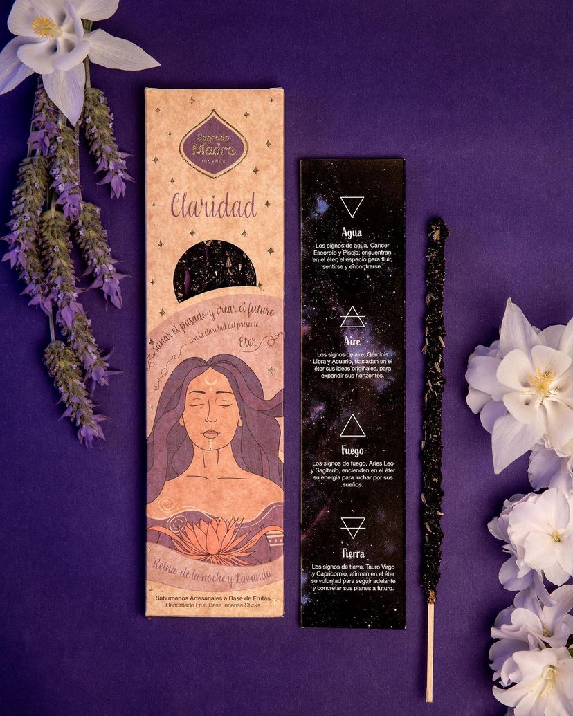 Claridad Ether incense pack on a purple background with lavender and white flowers
