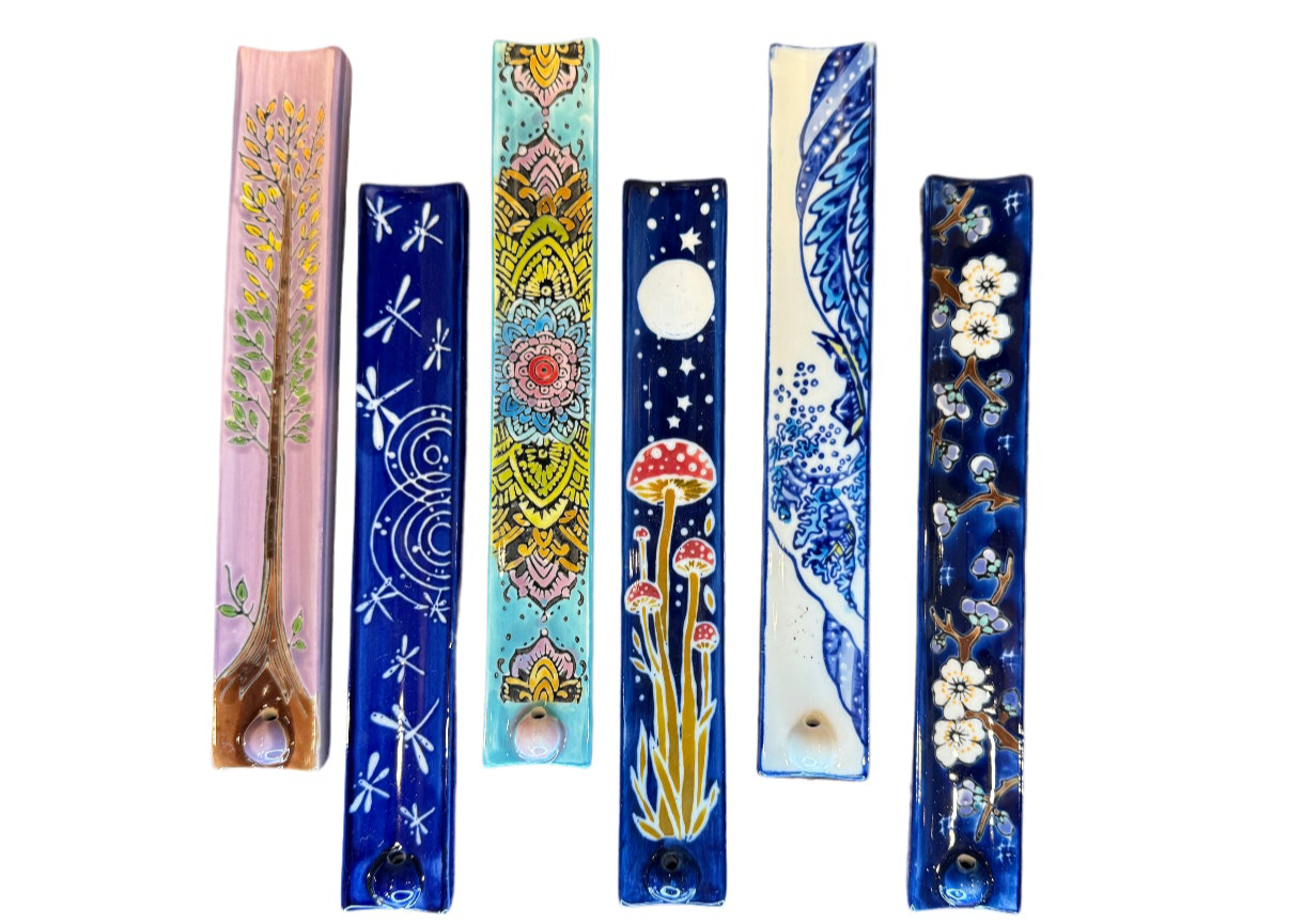 Six handpainted ceramic incense holders laid out side by side in different motifs