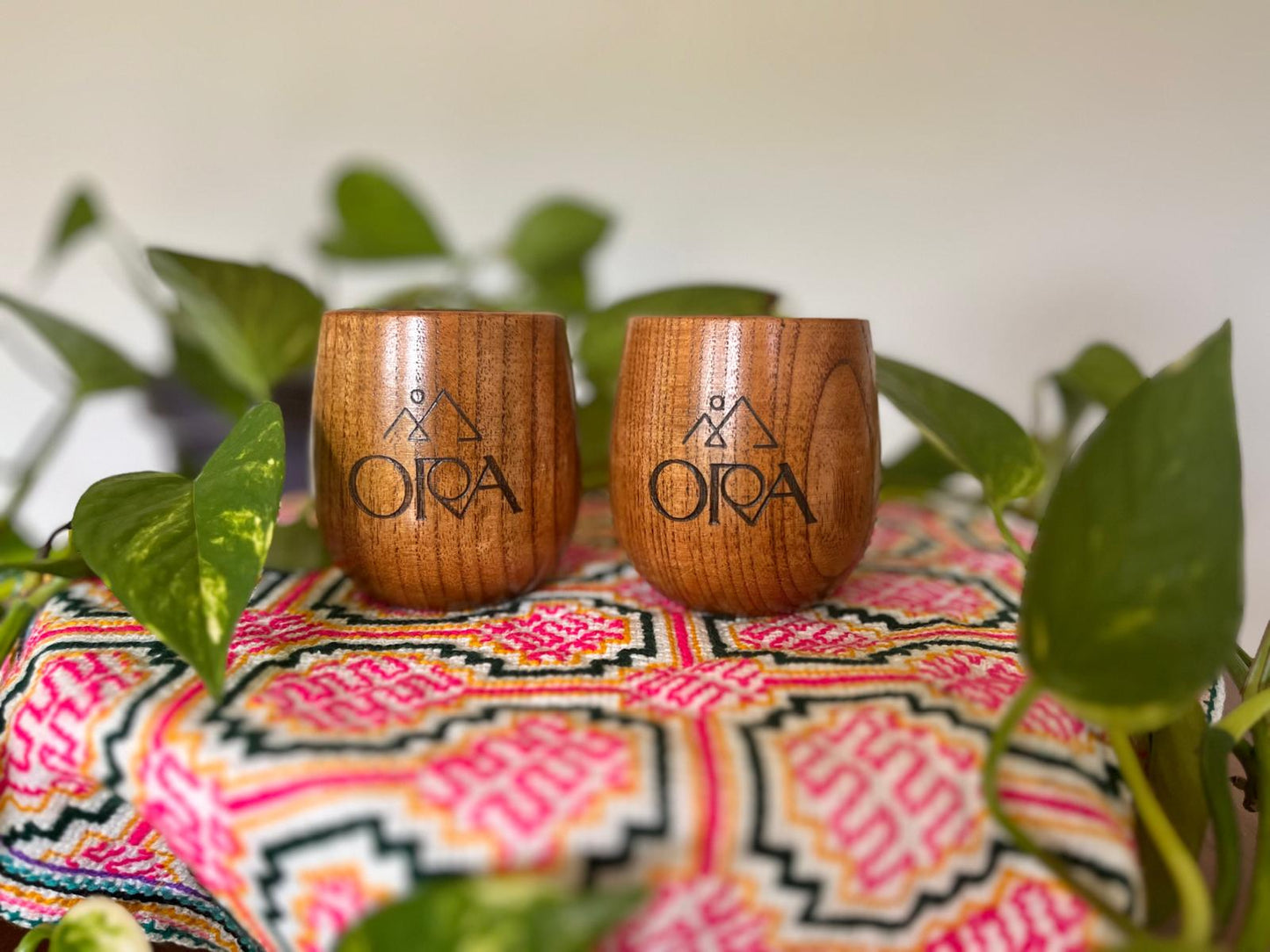 Laser-engraved wooden Ora Cacao ceremony cup shown in a warm, softly lit styled scene.