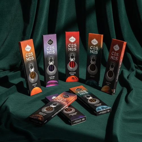 Seven Cosmos incense boxes on dark green velvet — Sun, Jupiter, Mars, Venus and Saturn standing upright, Moon and Mercury lying in front.
