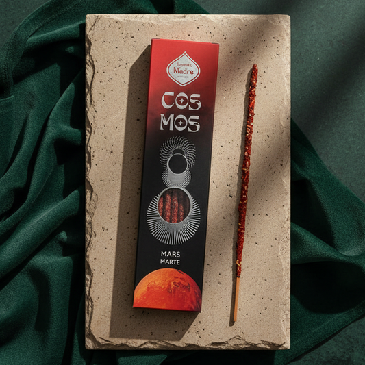 The Cosmos Mars incense box on a pale stone tile over dark green fabric, one red-flecked stick beside it.