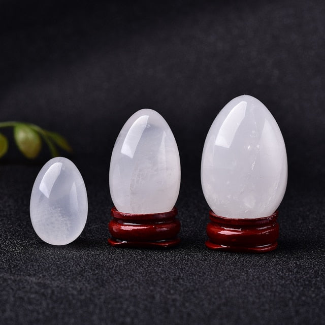 Polished carved crystal egg in assorted gemstones on a dark surface — view 8 of 10