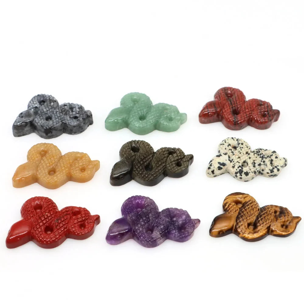 Carved gemstone snake figurine coiled on a dark surface — view 2 of 12