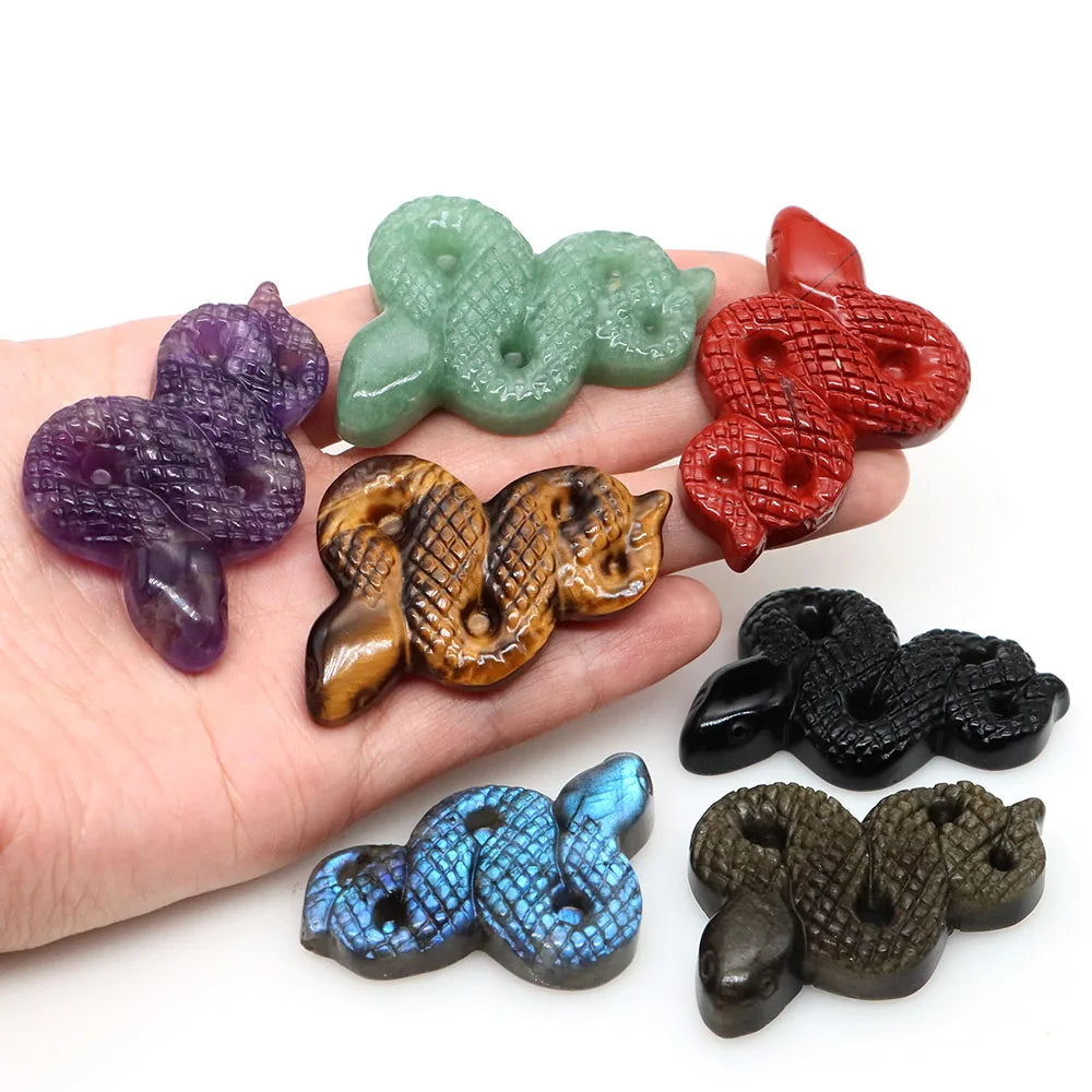 Carved gemstone snake figurine coiled on a dark surface — view 3 of 12