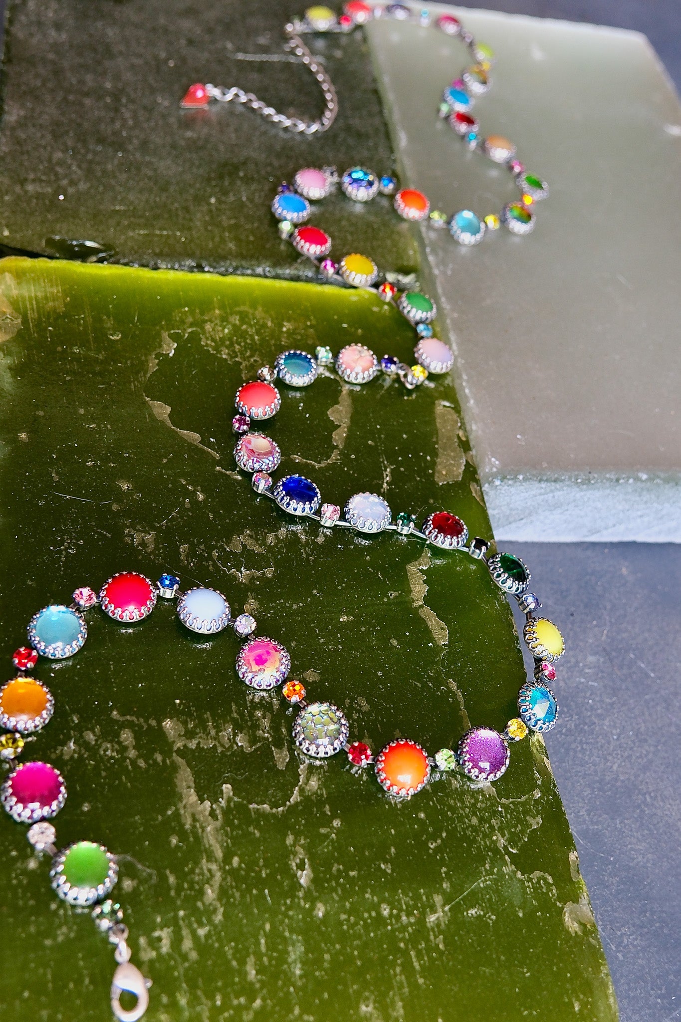 An oxidized silver waist chain strung with prismatic neon, opal and jewel-toned vintage glass stones.