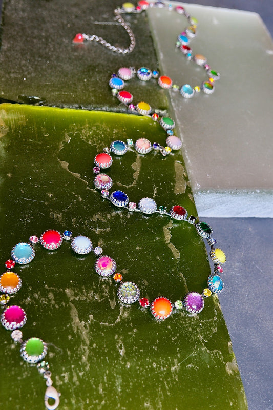 An oxidized silver waist chain strung with prismatic neon, opal and jewel-toned vintage glass stones.