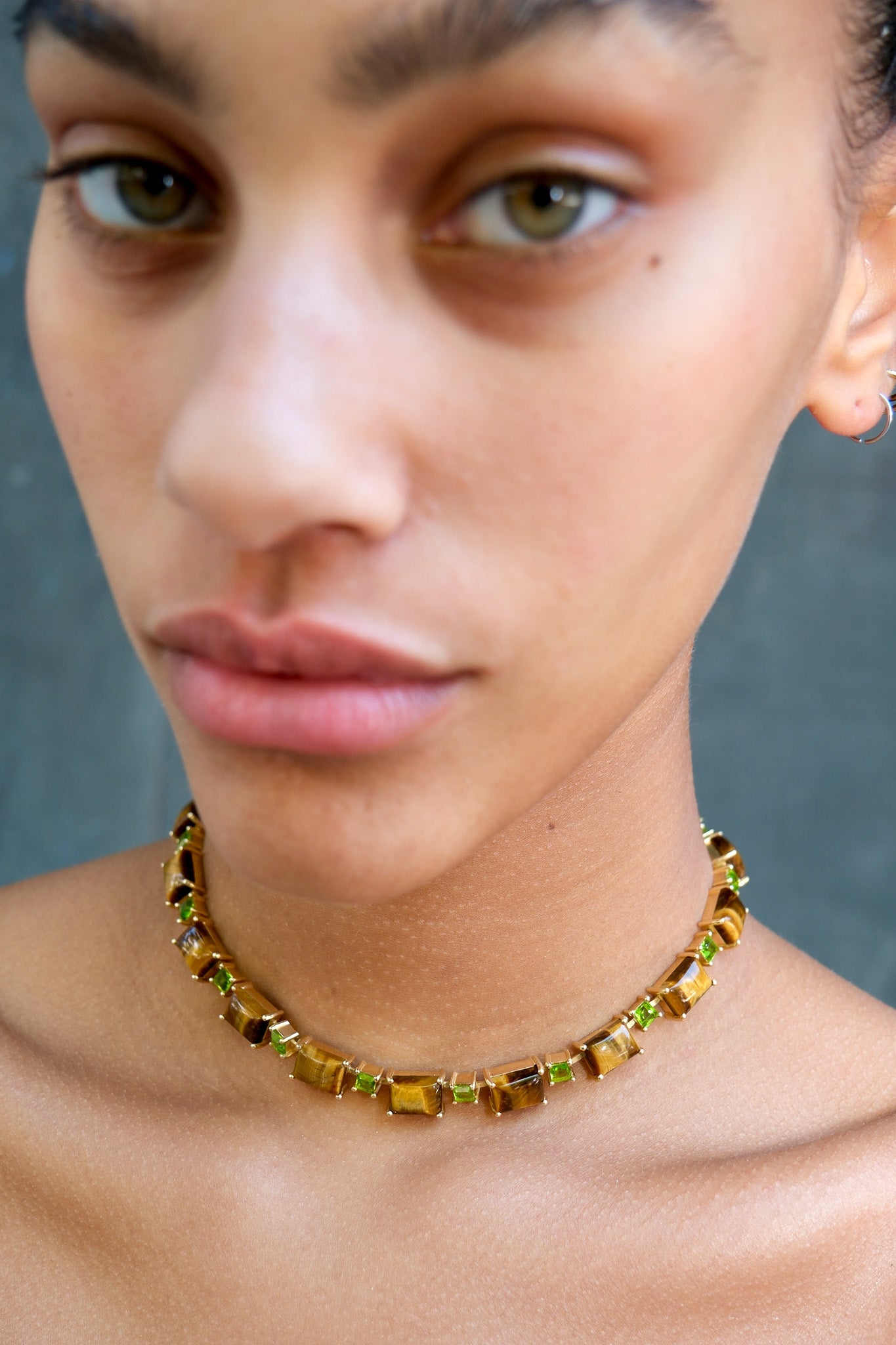 A gold-plated Battlement choker set with genuine tiger eye stones and bright green glass crystals, shown from a different angle.