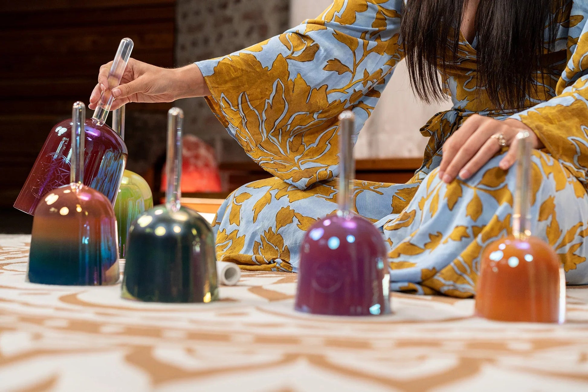 Colored crystal singing bowls from the set displayed together in a calm, styled interior.