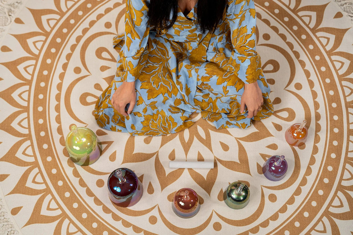 Colored crystal singing bowls from the set shown in a warm, styled tabletop scene.