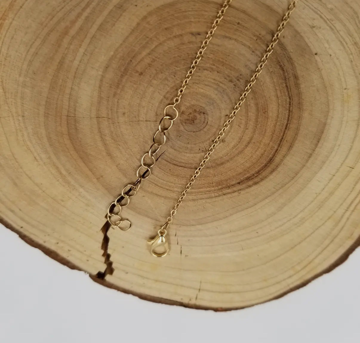 The wire-wrapped green fluorite necklace laid flat to show the stone's organic edges.