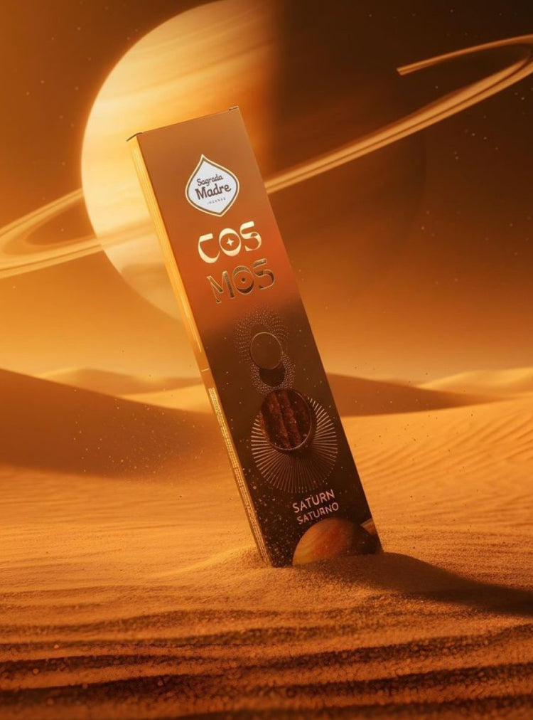 Saturn Cosmos incense box standing on golden sand beneath the planet Saturn