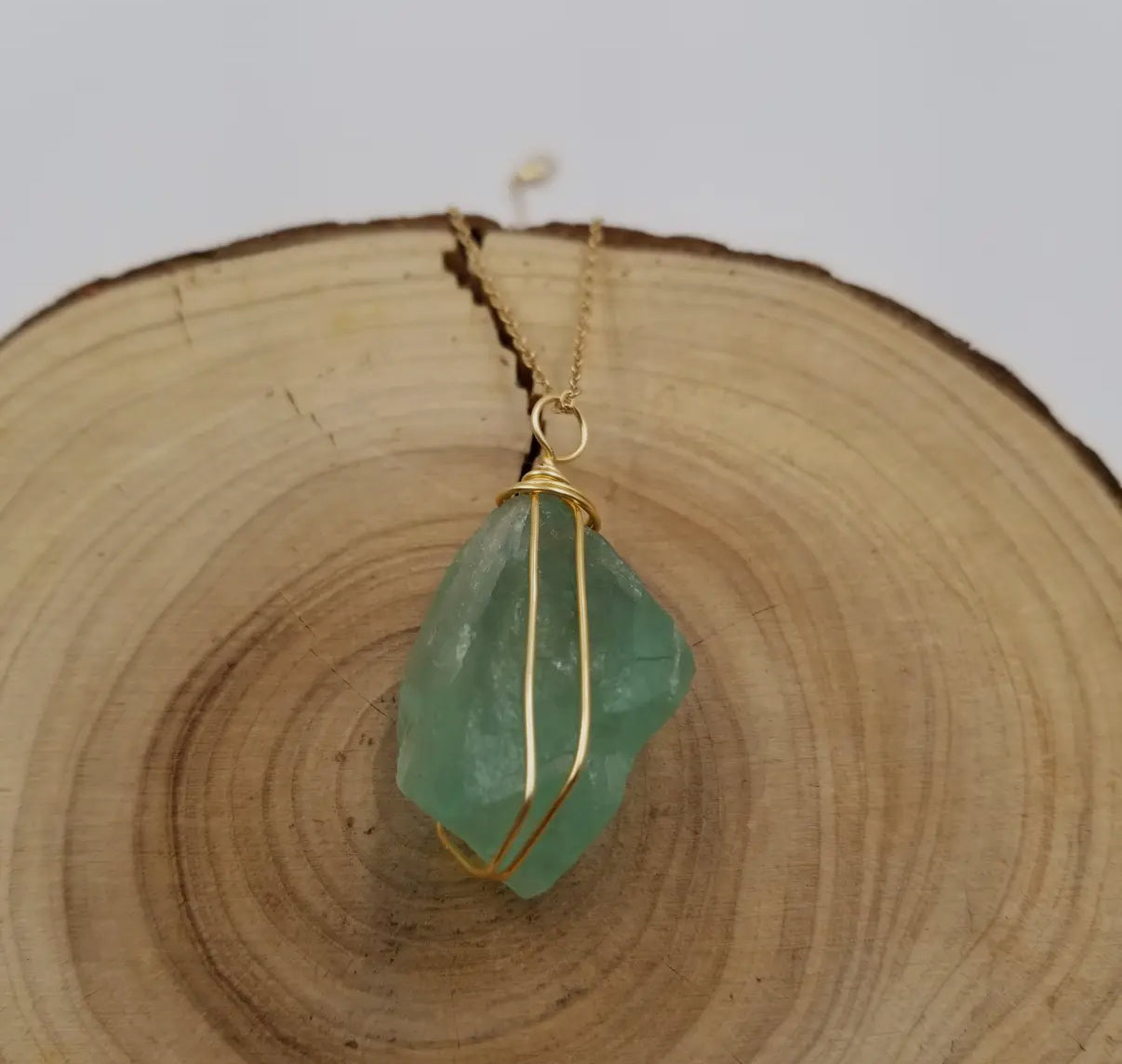 Close-up of the raw green fluorite crystal showing its natural translucence.