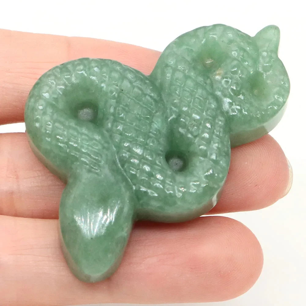 Carved gemstone snake figurine coiled on a dark surface — view 11 of 12