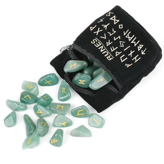 Set of twenty-five carved crystal runes laid out beside a velvet drawstring storage bag