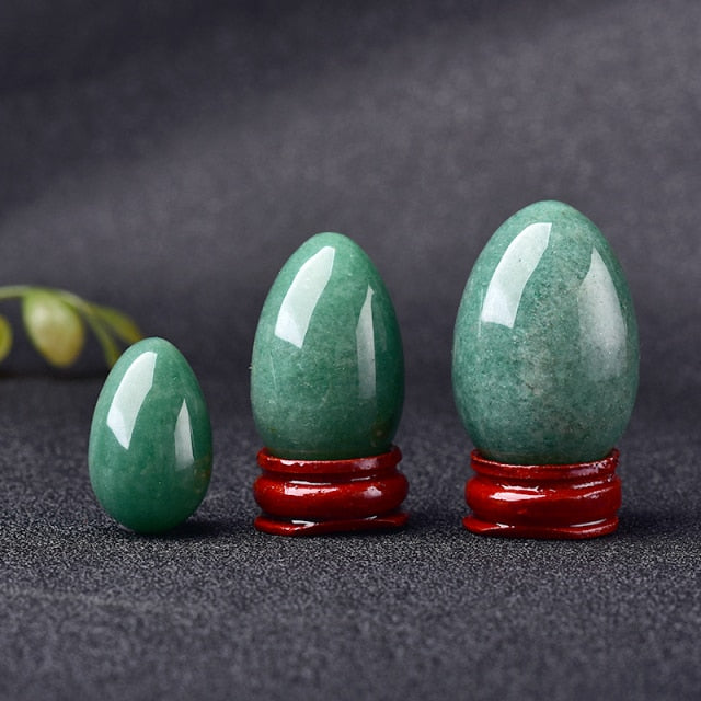 Polished carved crystal egg in assorted gemstones on a dark surface — view 7 of 10