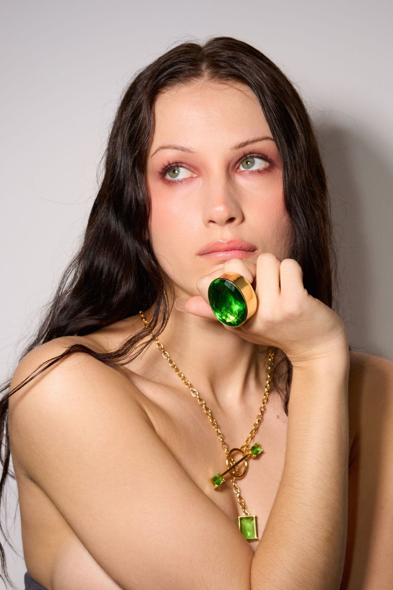 Oval Colossus Ring in Green Envy — oversized faceted green glass oval in a tall gold-plated setting on a wide band — view 2