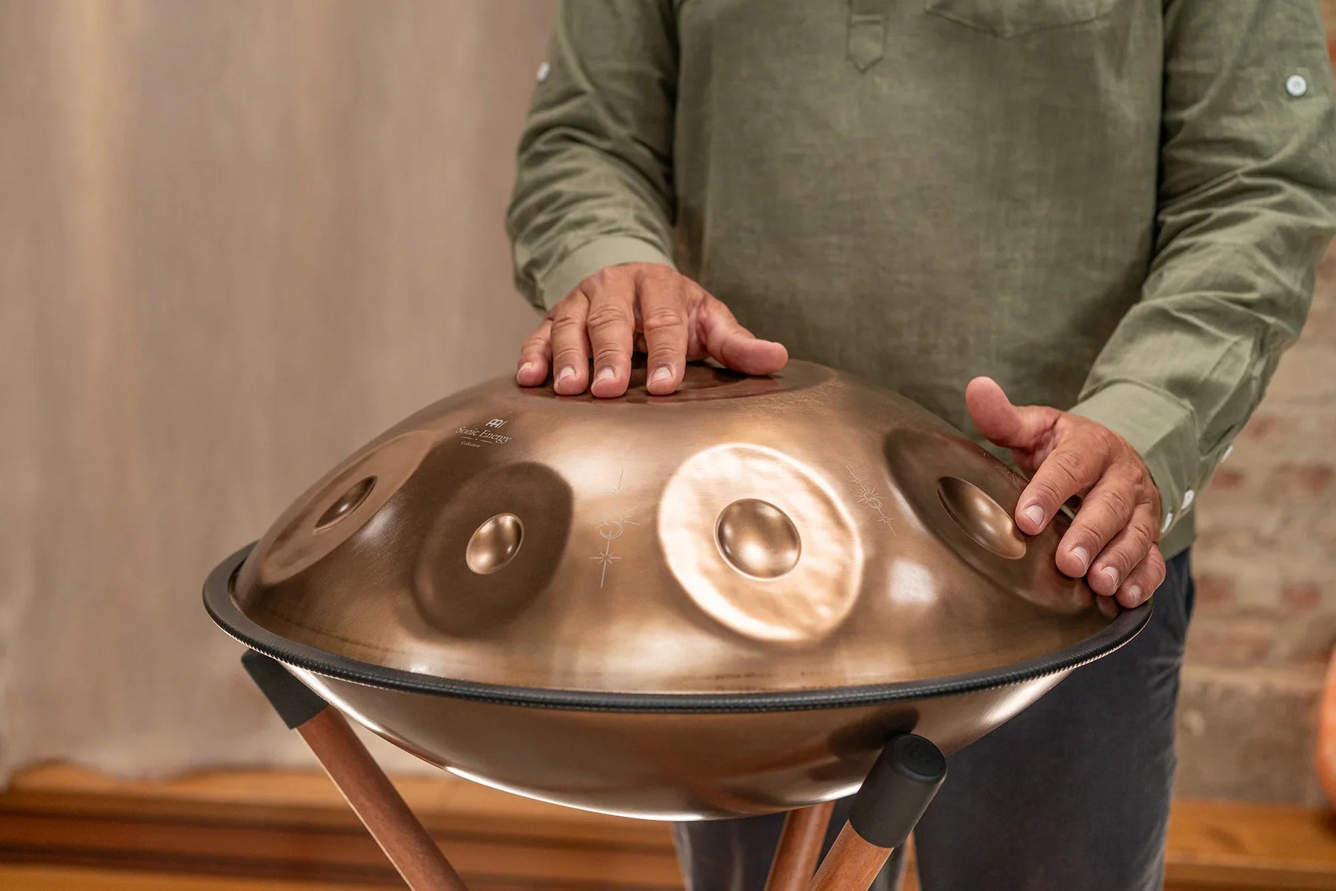 Vintage copper Sensory handpan with engraved design shown in a warm, softly lit styled scene.