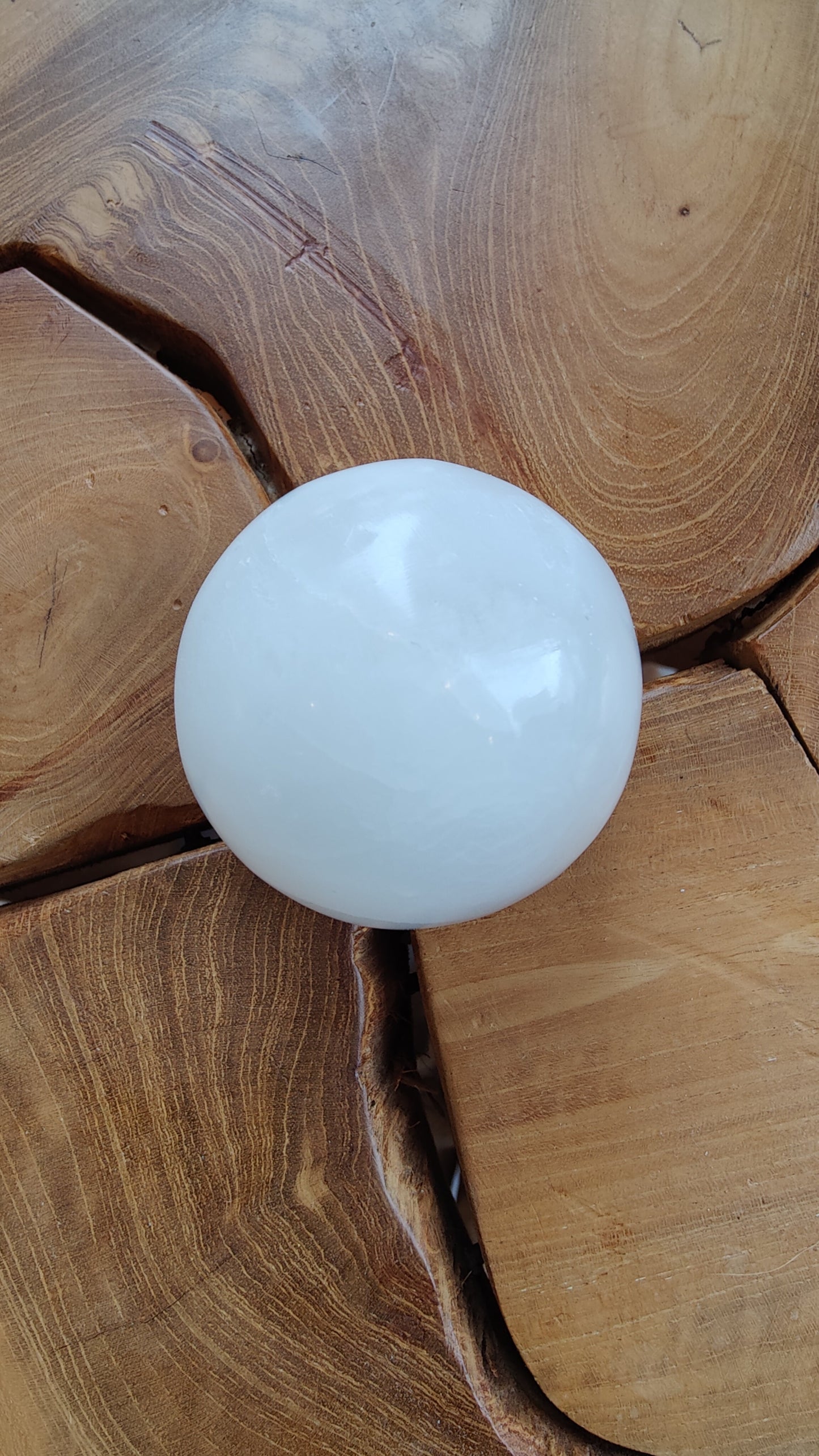 Selenite sphere photographed against a dark background