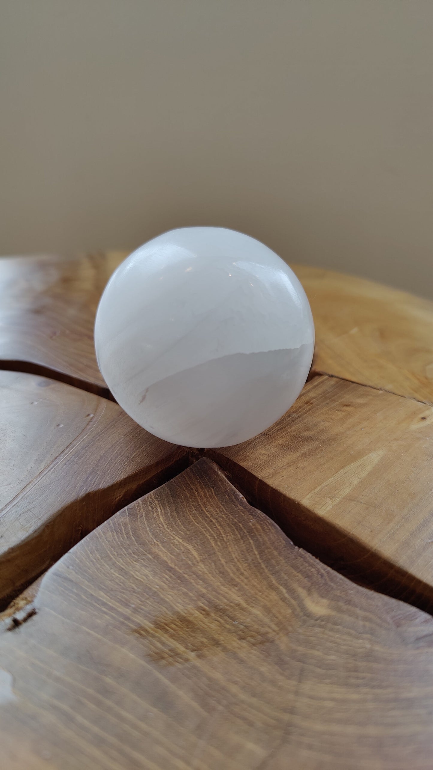 Selenite sphere held for scale