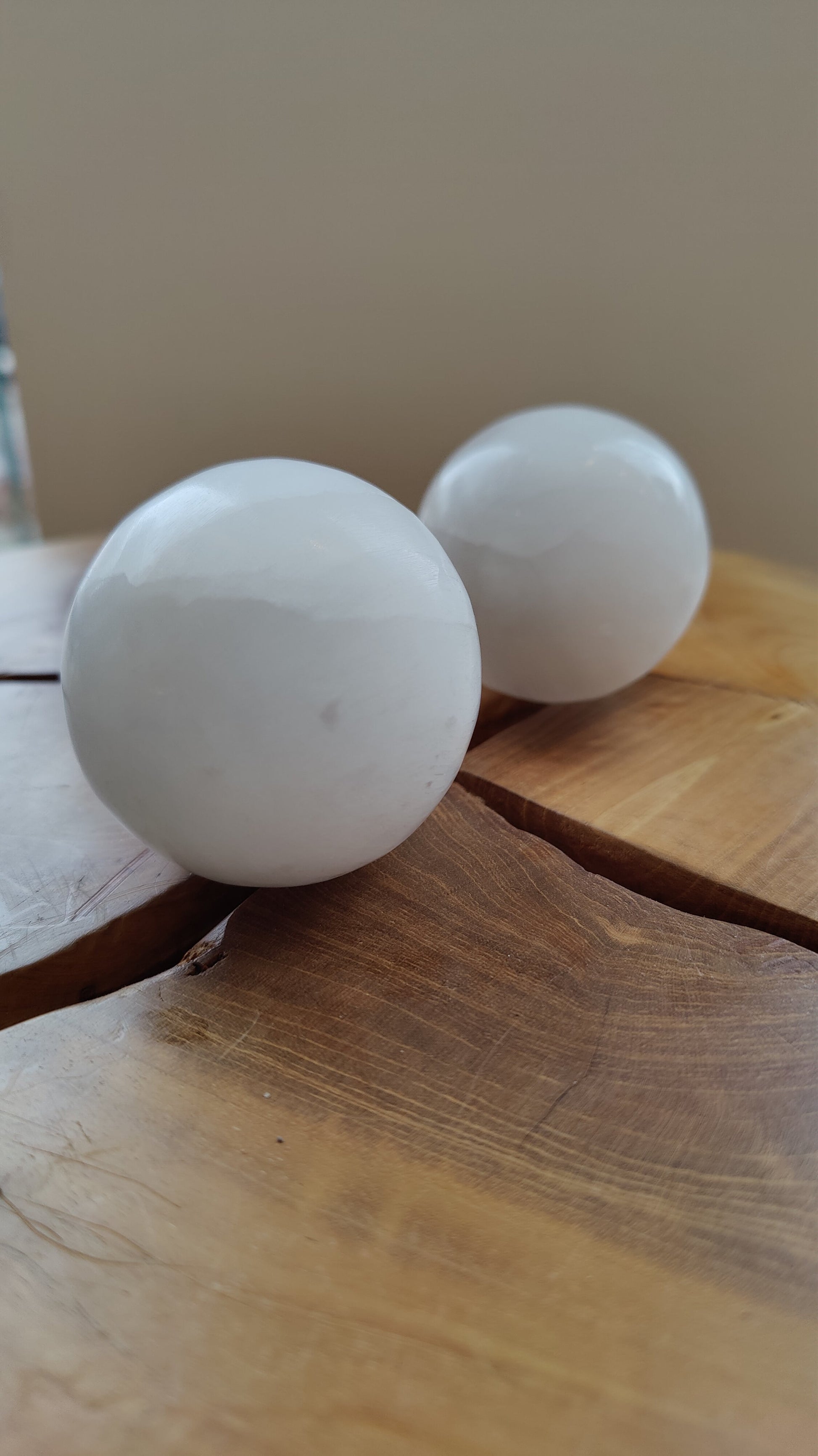 Polished selenite sphere resting on a dark surface