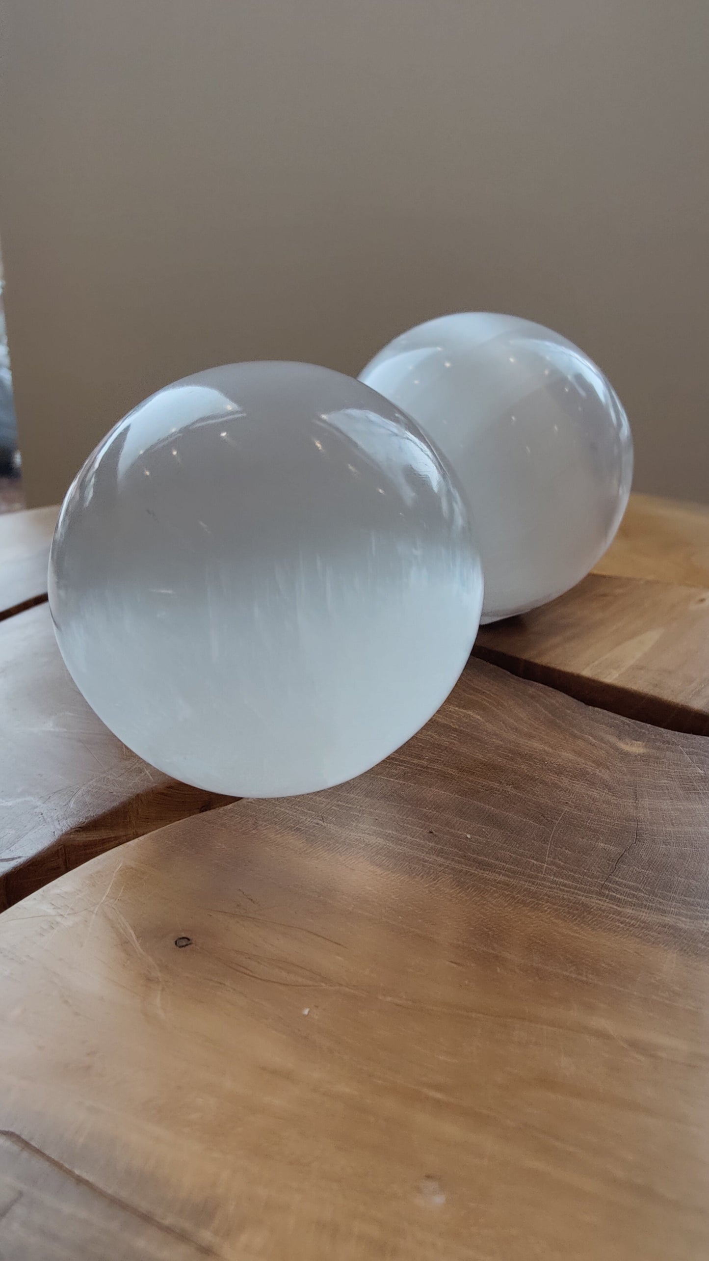Large polished selenite sphere on a dark surface