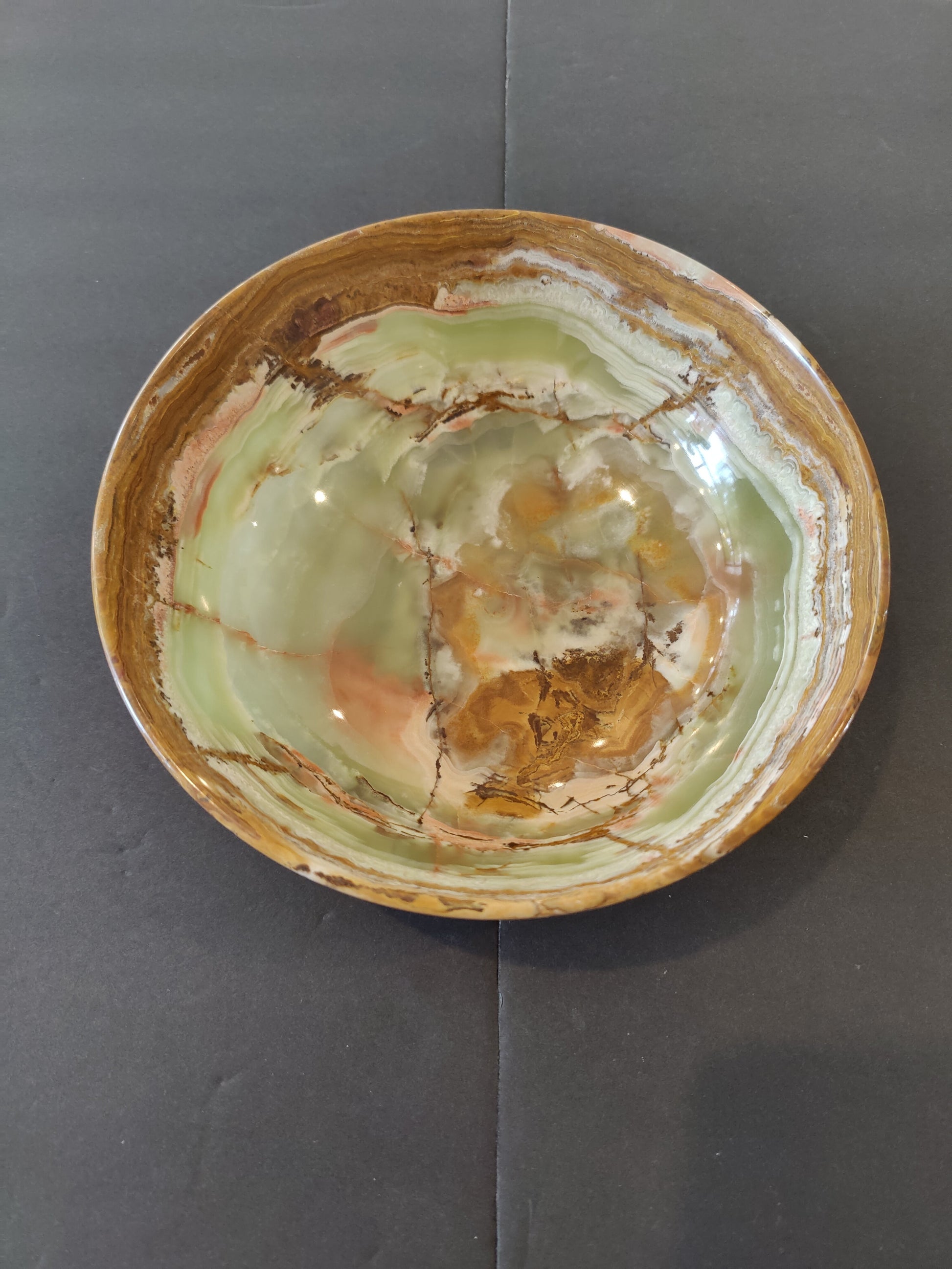 Eight-inch bowl carved from banded green onyx, translucent with pale and deep green layers