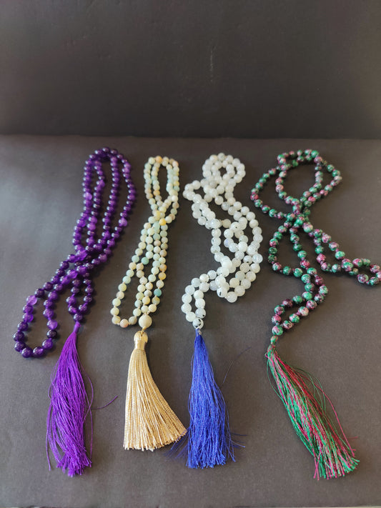 Long mala necklace strung with assorted natural stone beads, hanging in a loop