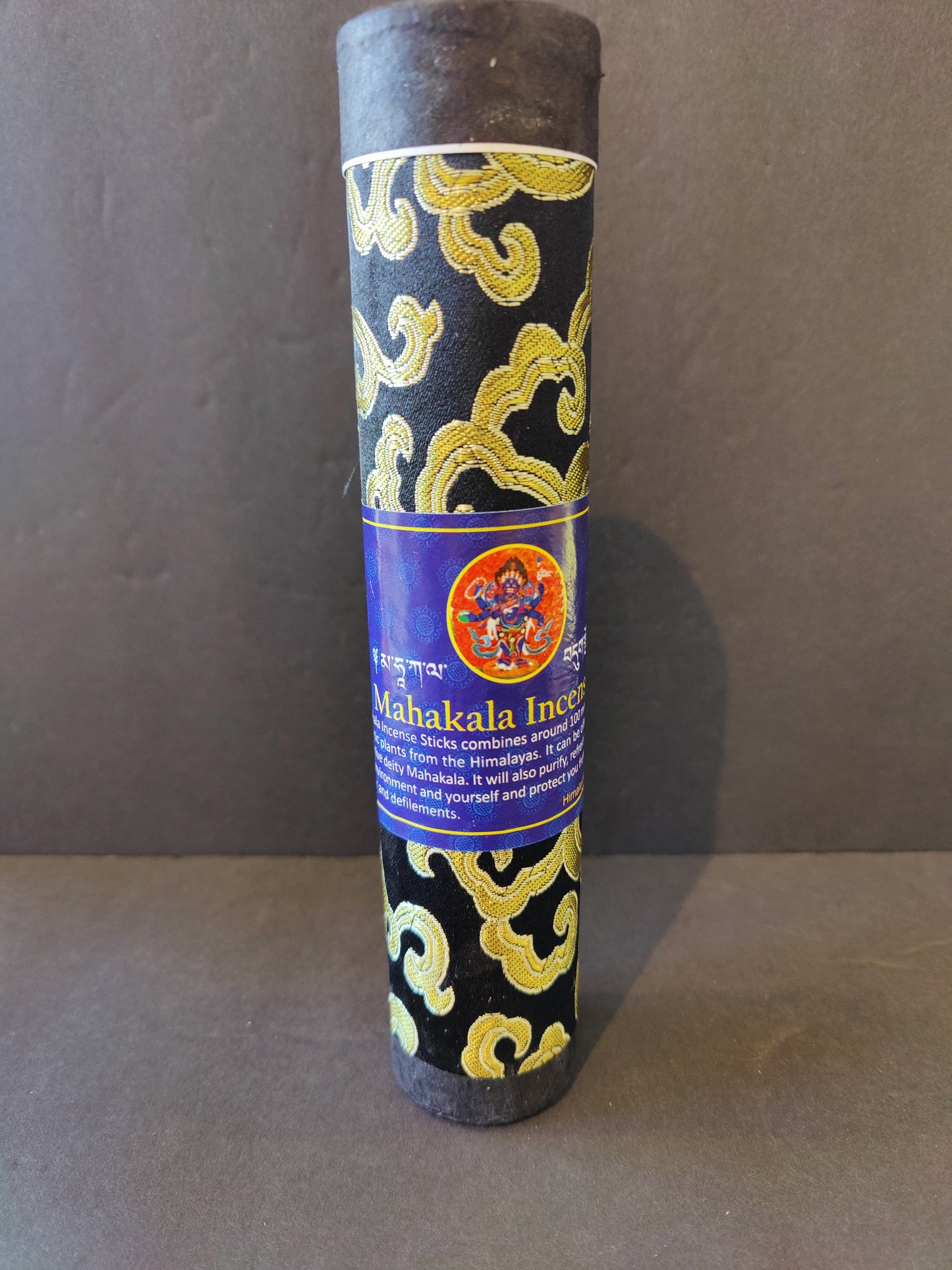 Bundle of hand-rolled Tibetan incense sticks from Nepal tied with cord, on a dark surface — view 4