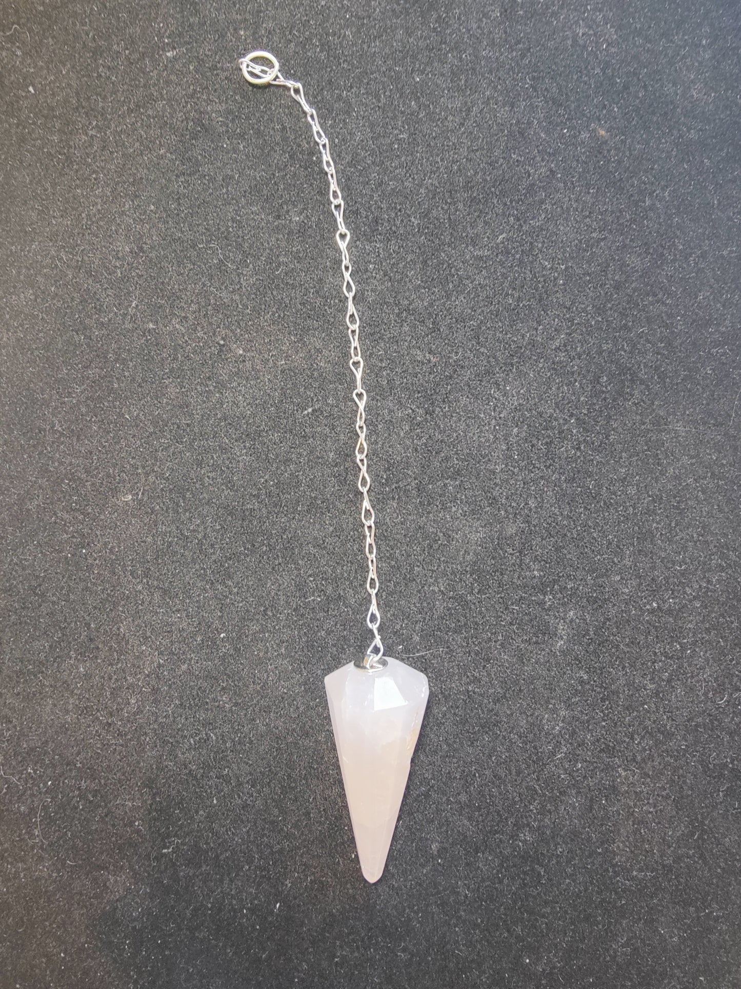 Faceted stone pendulum hanging from a seven-inch metal chain against a dark background — view 6