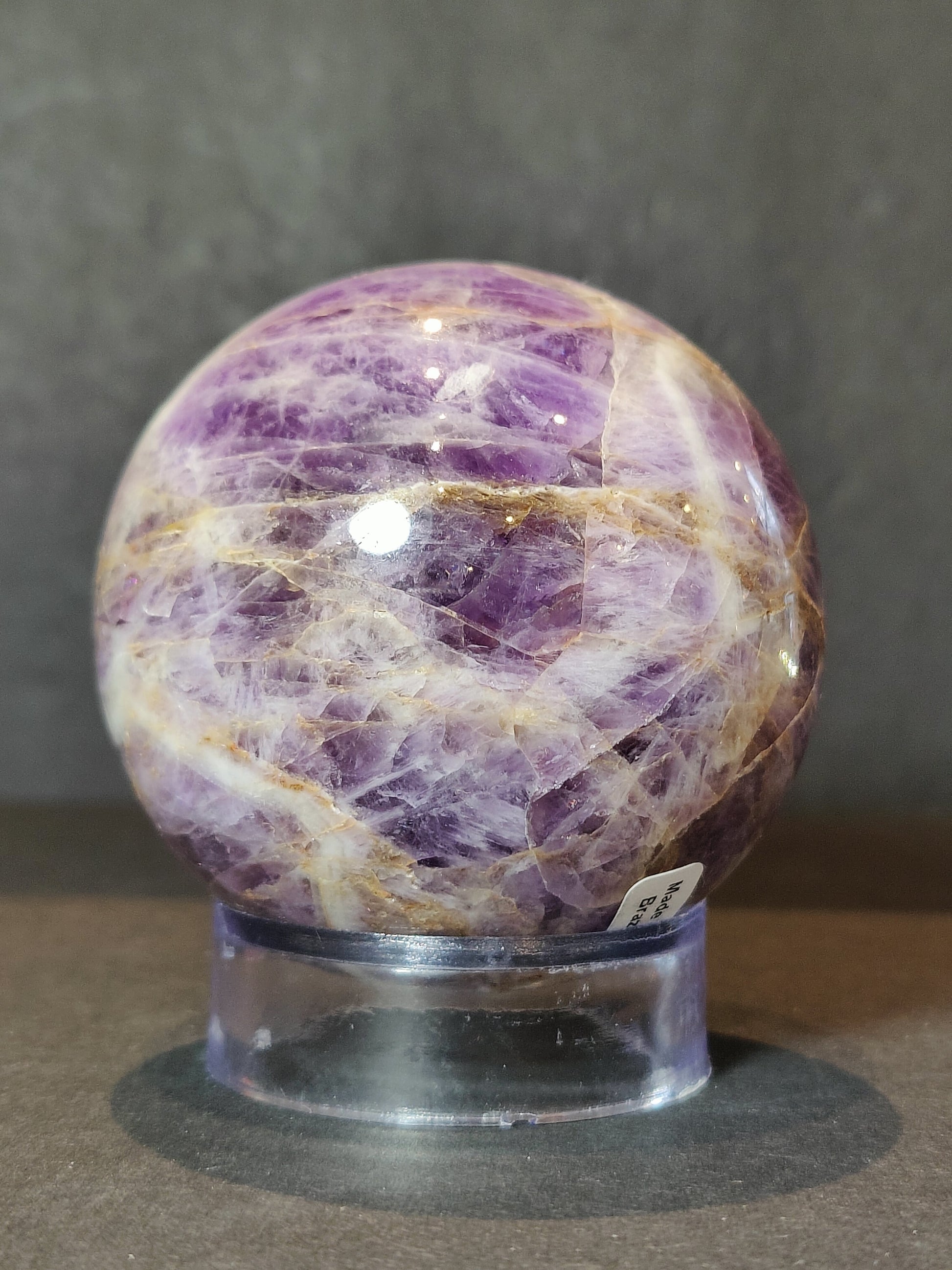 Polished chevron amethyst sphere with V-shaped bands of purple and white quartz — view 4