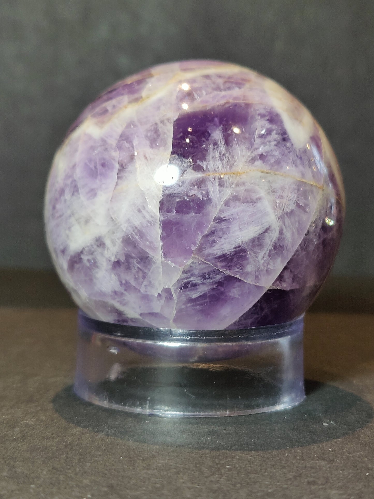 Polished chevron amethyst sphere with V-shaped bands of purple and white quartz — view 5