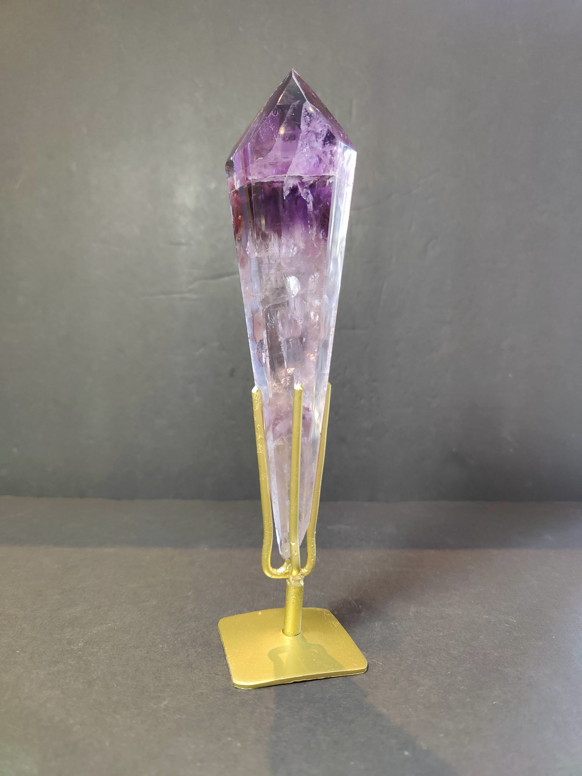 Three amethyst scepter wands of assorted sizes side by side