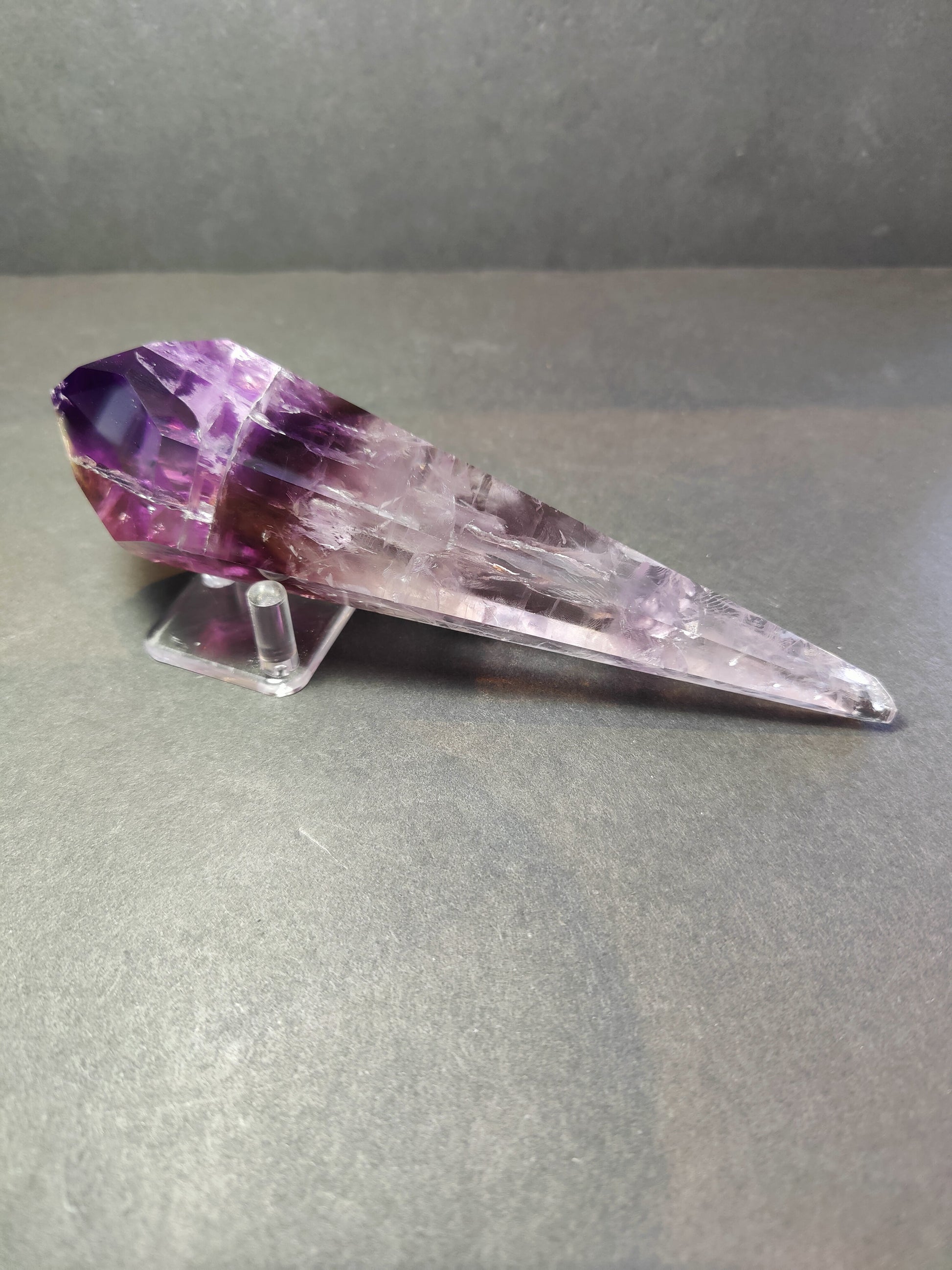 Amethyst scepter wand photographed against a dark background
