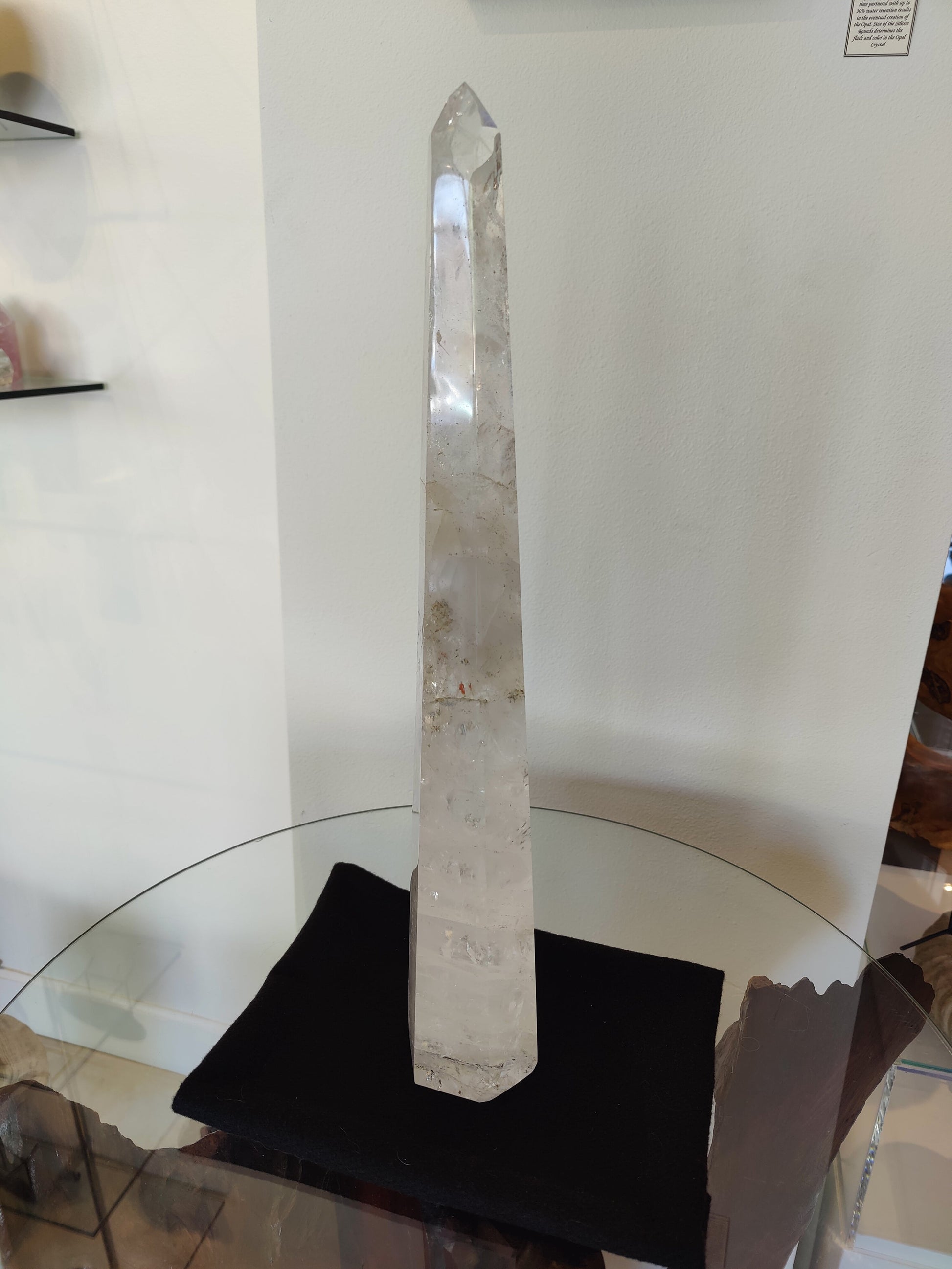 Tall polished clear quartz obelisk standing 20.5 inches, with natural internal veils