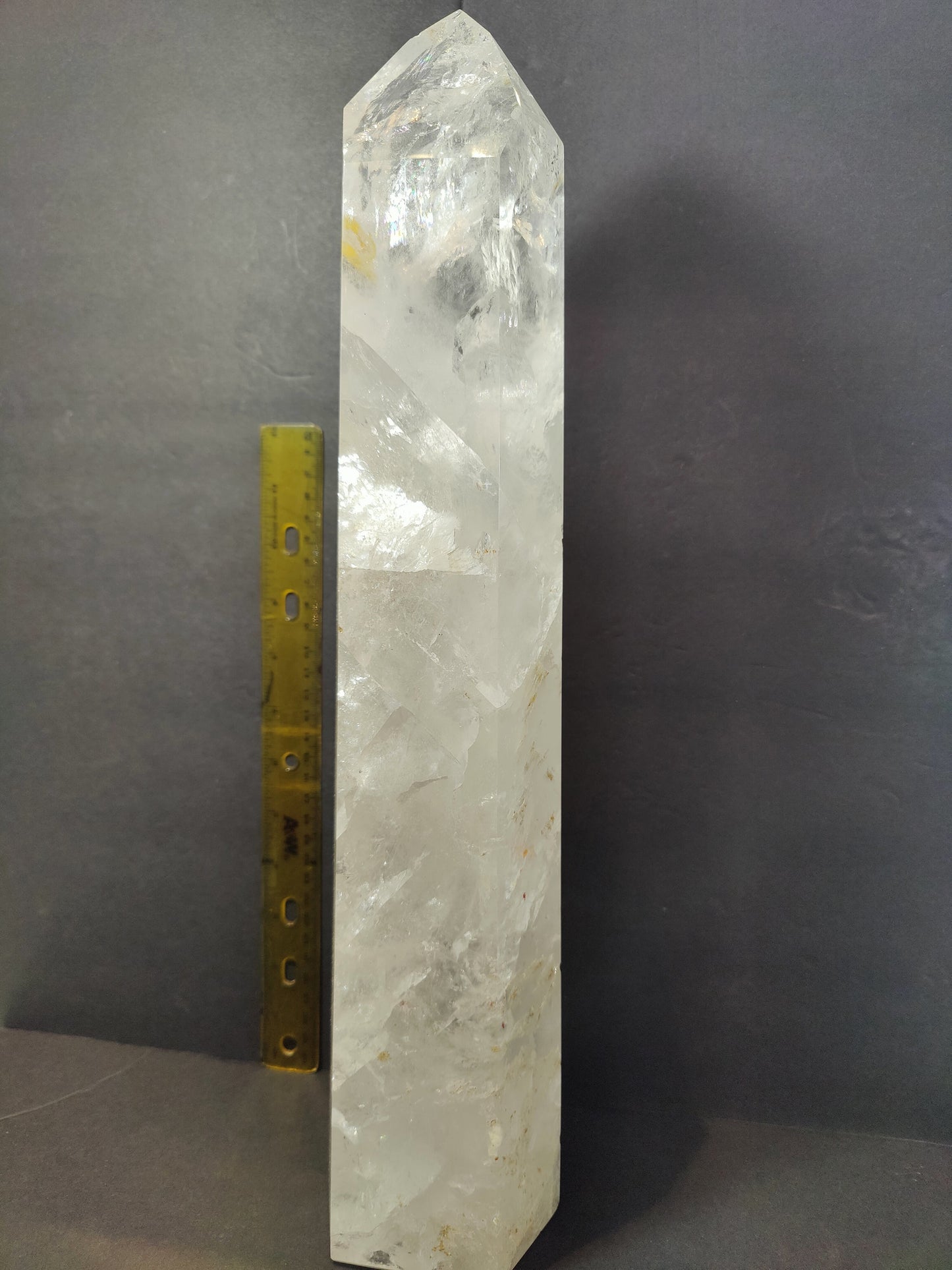 Clear quartz obelisk photographed from the side showing internal veils