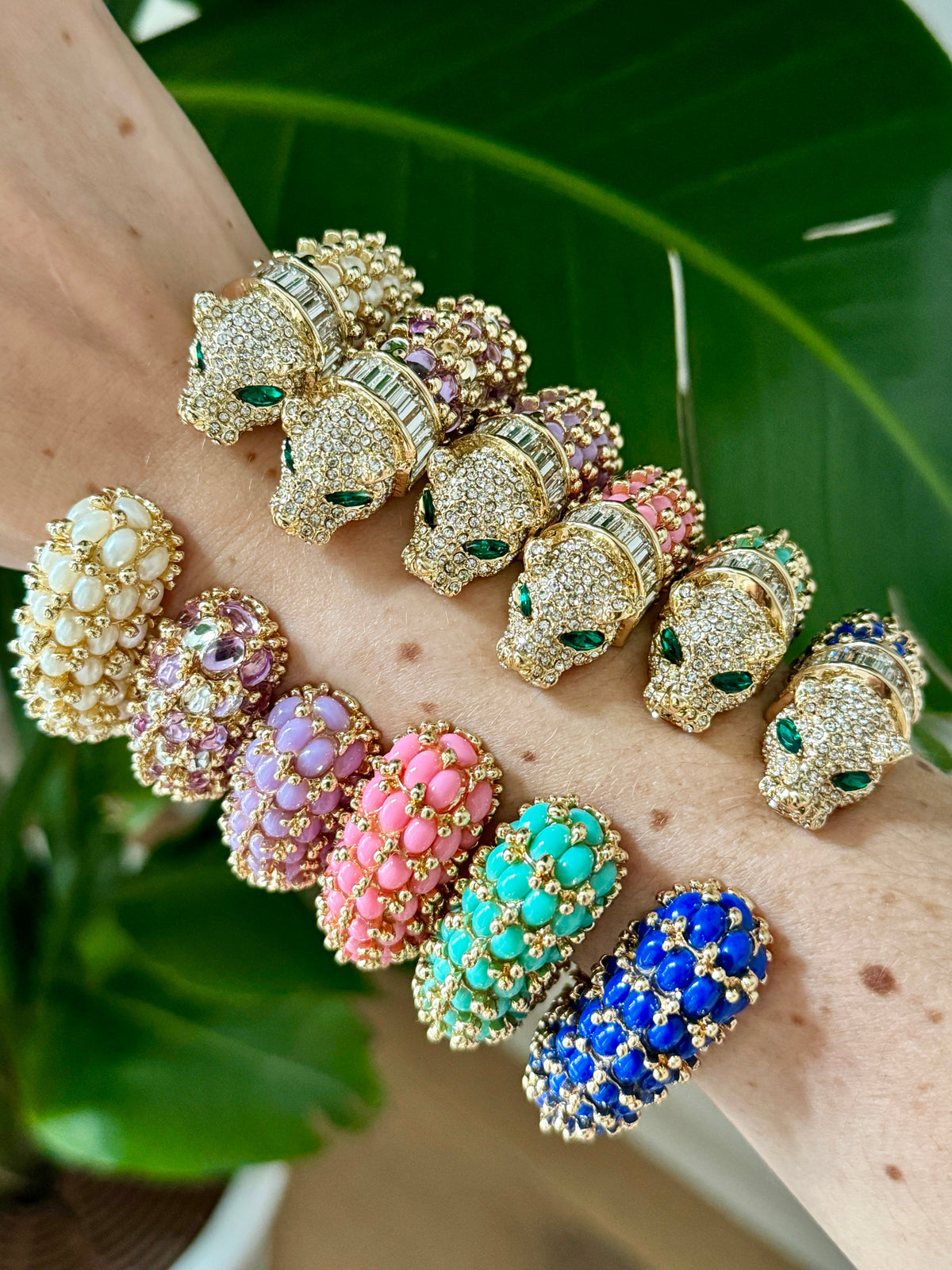Six colorways of the panther cuff worn stacked on one wrist against a leaf; this listing is the navy blue one.