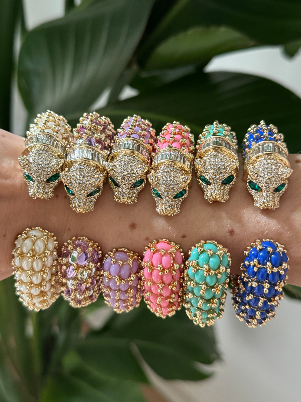 Six panther cuffs from the line photographed head-on against a leaf; this listing is the bright pink one.