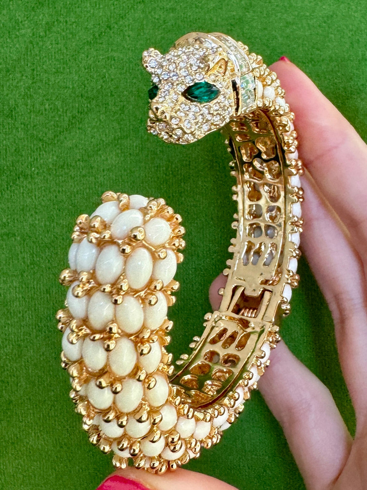 Six colorways of the panther cuff worn stacked on one wrist against a leaf; this listing is the white one.