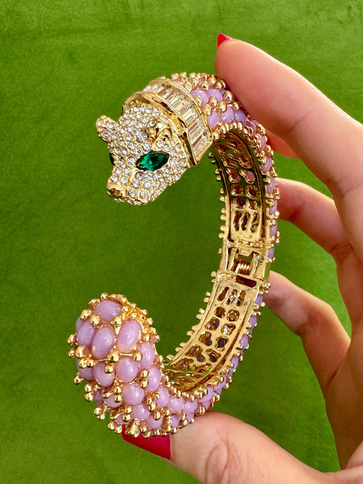 The lavender panther cuff held up from the side, the baguette-set collar sitting behind the pavé head.
