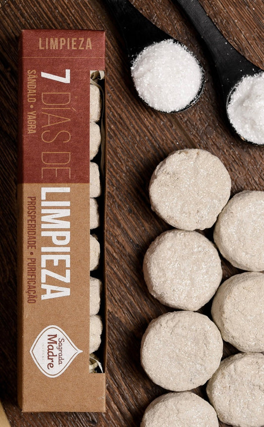 Limpieza seven-day charcoal tablet box with the pale herb-topped disks laid out beside it