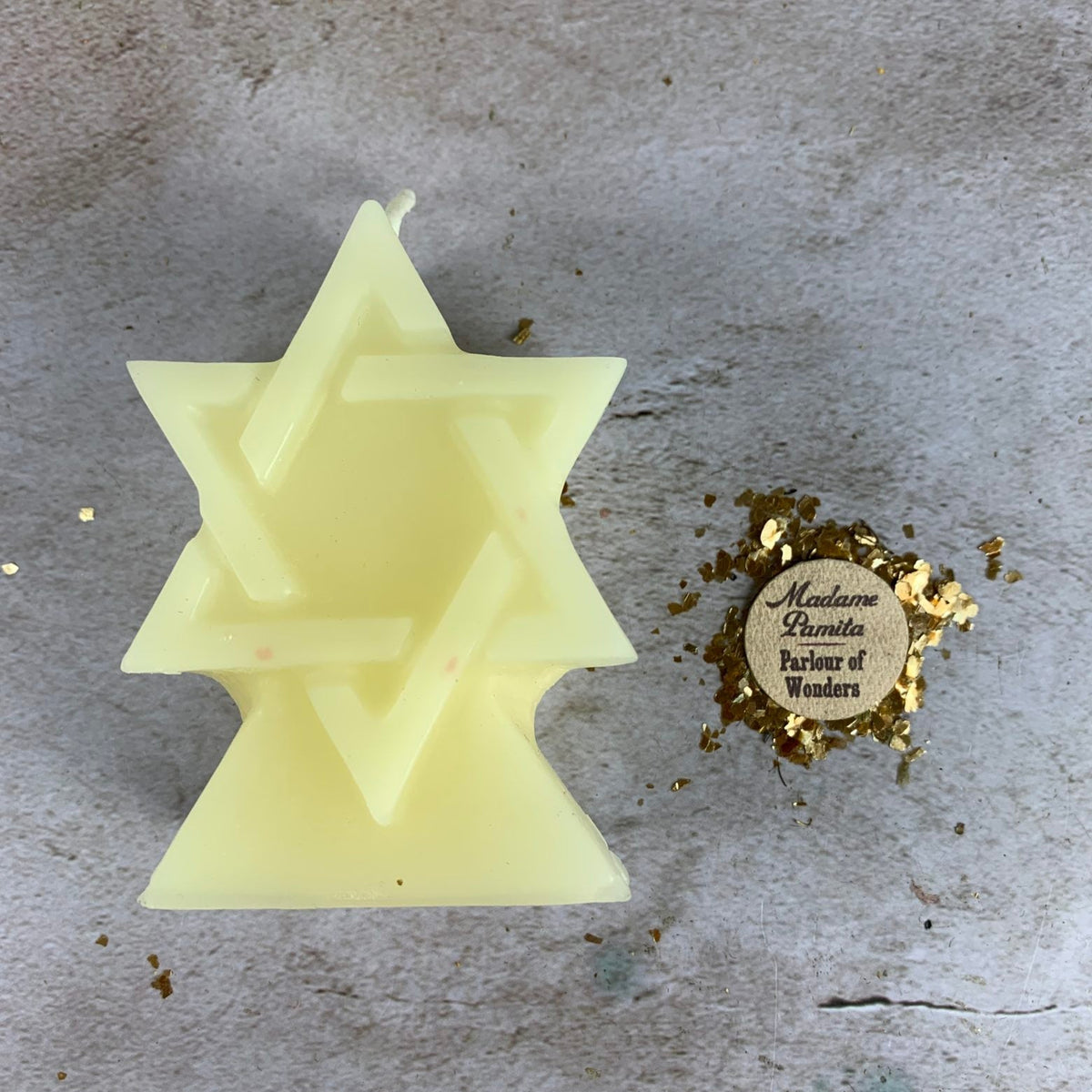Pale cream yellow beeswax Seal of Solomon hexagram candle on pale stone