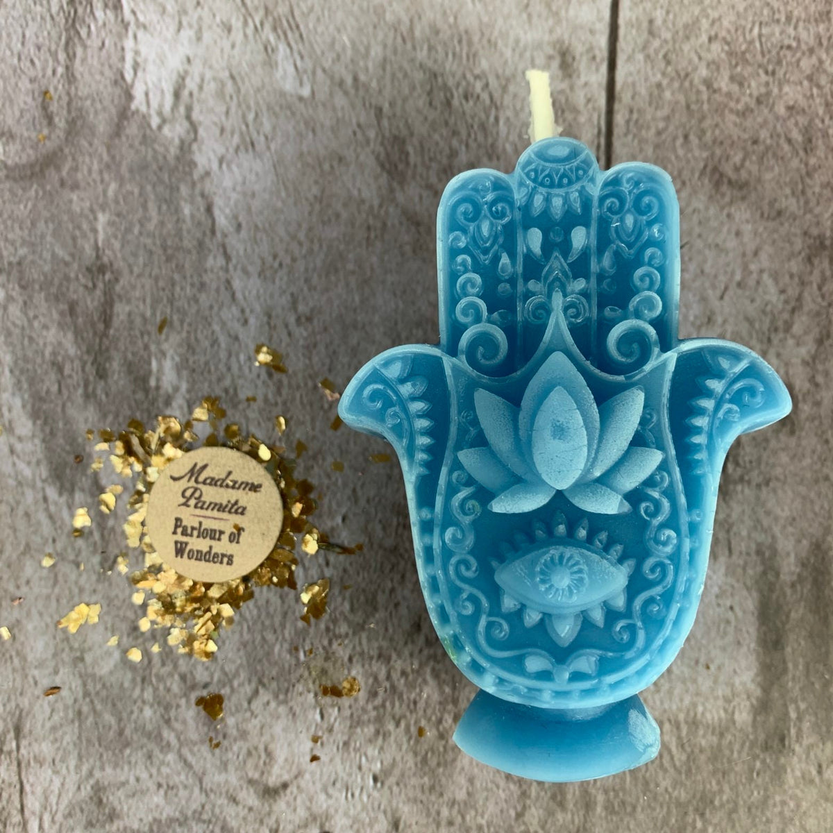 Sky-blue Hamsa candle, the raised lotus and eye picked out in lighter blue.