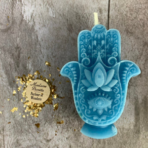 Sky-blue Hamsa candle, the raised lotus and eye picked out in lighter blue.