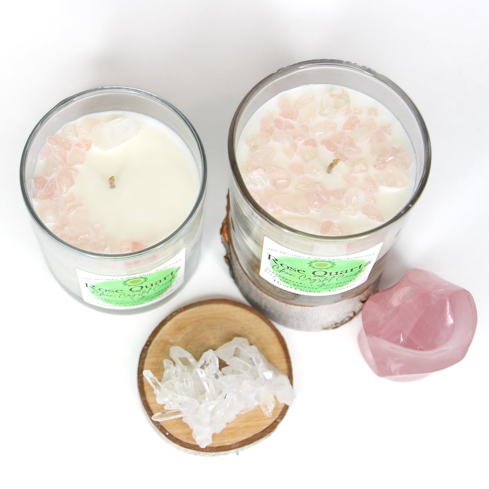 The Rose Quartz chakra candle lit on a dark surface