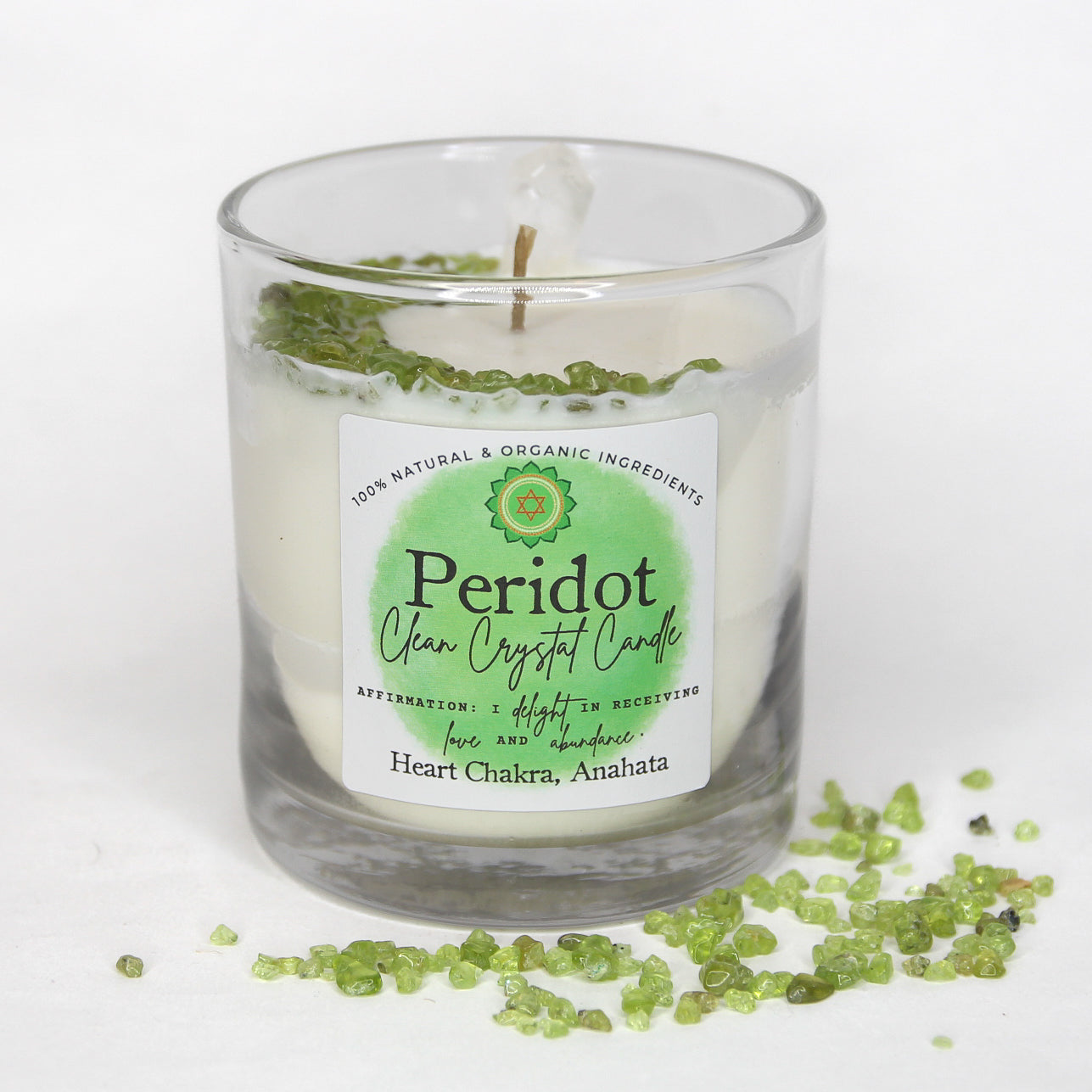 Peridot Clean Crystal Candle in a clear lead-free glass tumbler, topped with green peridot chips and a clear quartz point — product photo 4