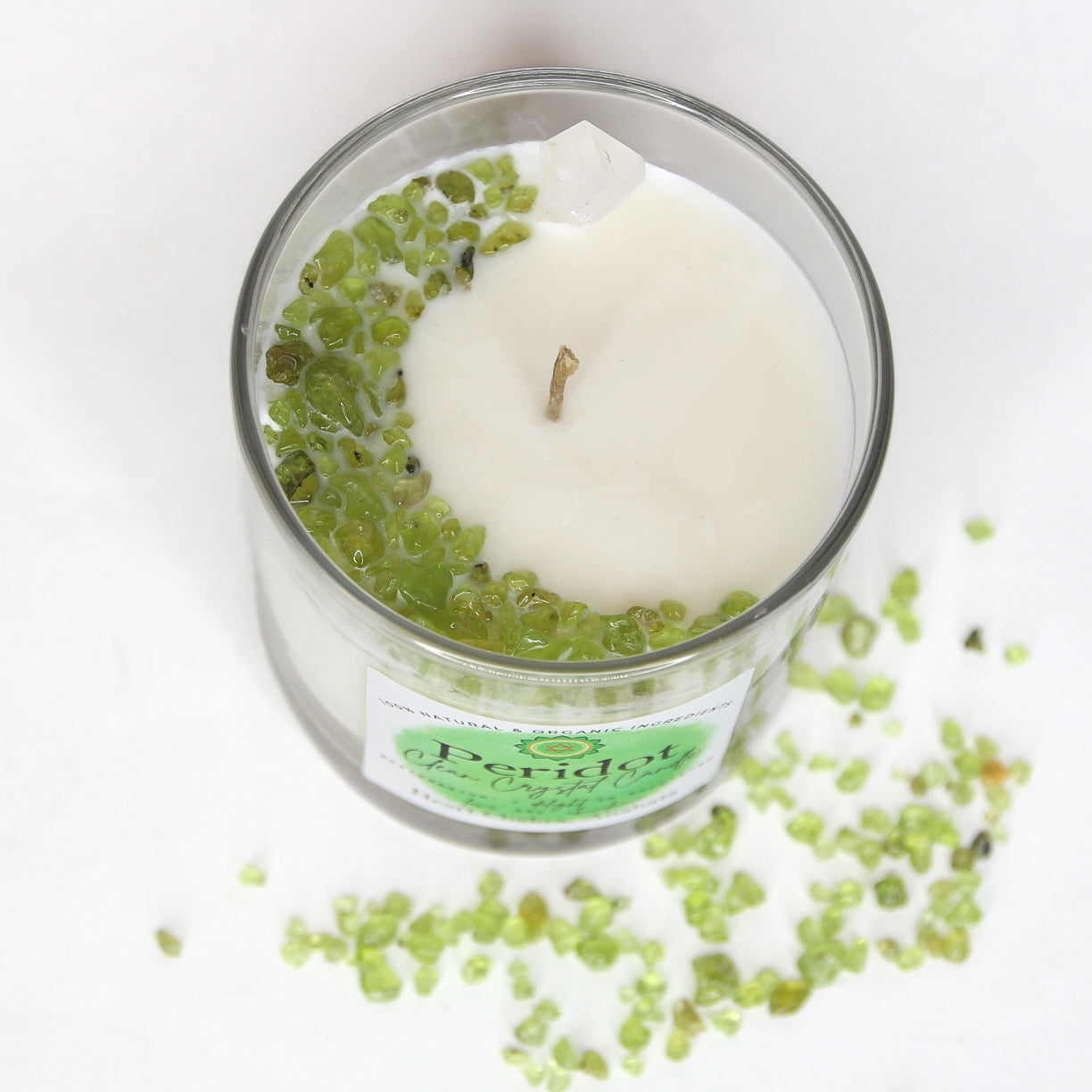 Peridot Clean Crystal Candle in a clear lead-free glass tumbler, topped with green peridot chips and a clear quartz point — product photo 5