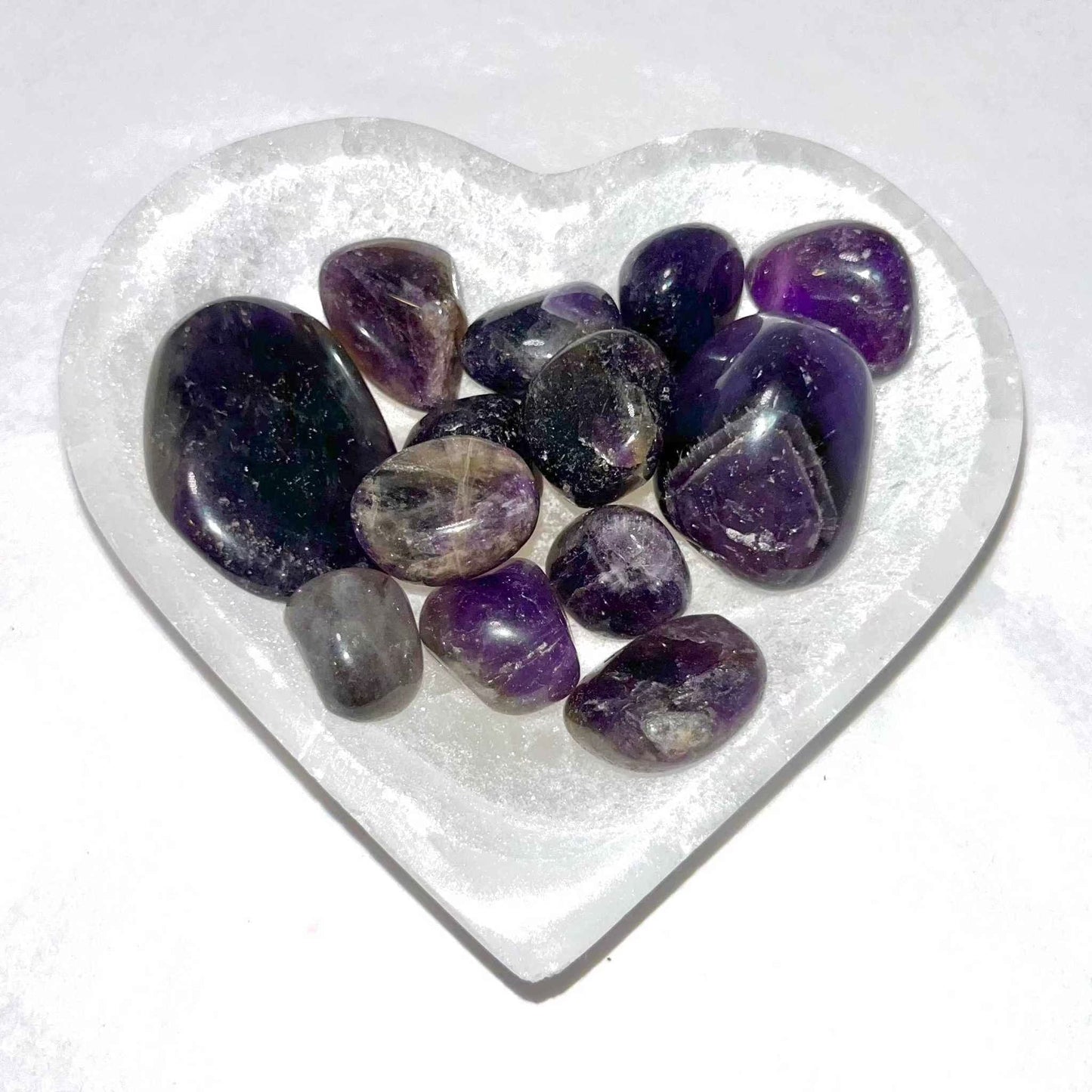 Smooth amethyst pocket stone against a plain background