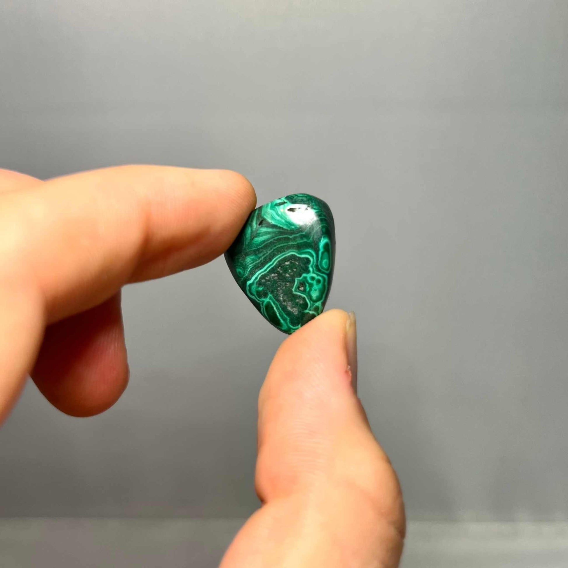 Several Malachite tumbled stones showing natural variation in pattern