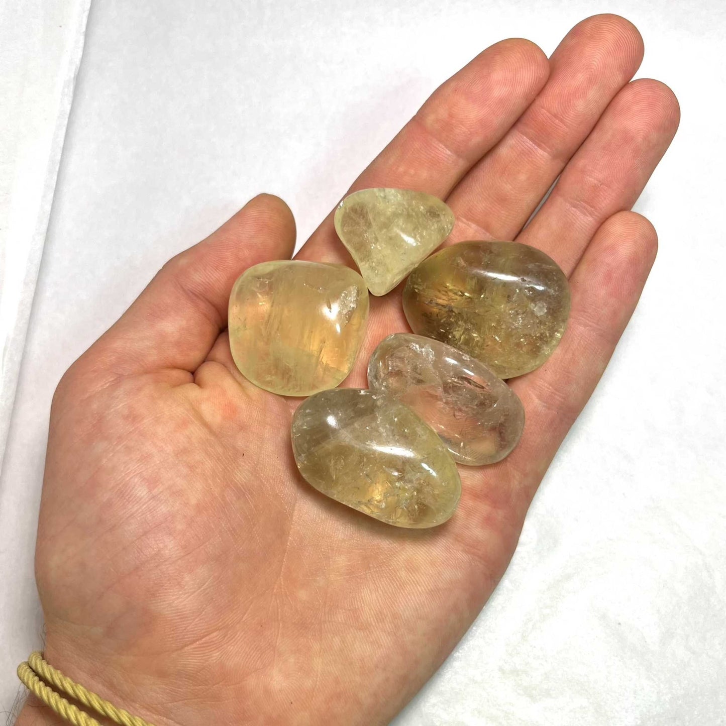 Pale golden natural citrine tumbled stone with warm translucency, further view